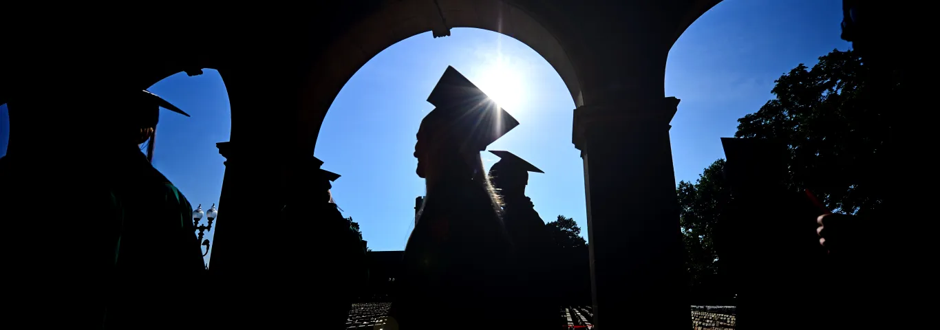 students walking in graduation caps and gowns